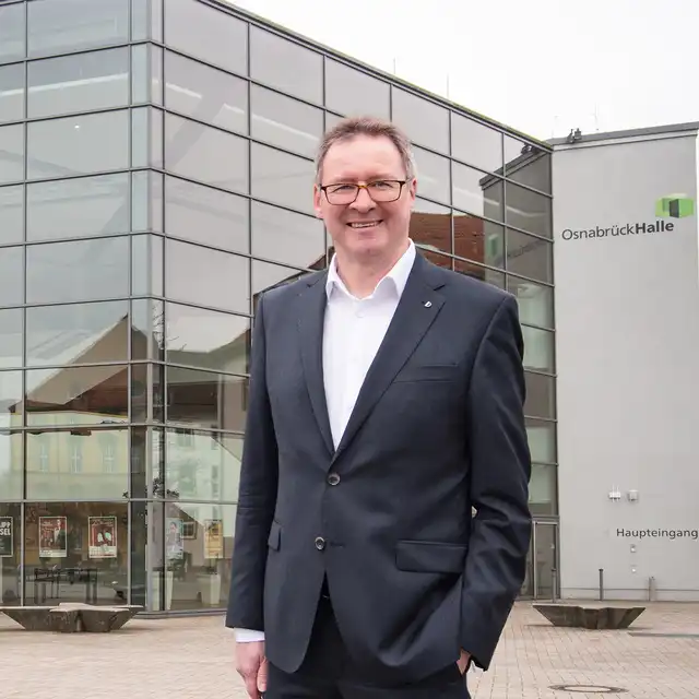 Andreas Alker vor einem verglasten Gebäude