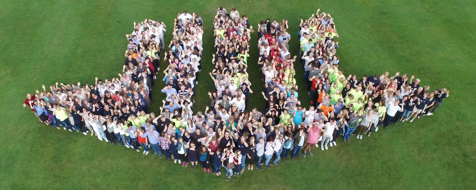 Mitarbeiter von wetreu, die das wetreu Logo formen