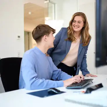Ein Mann und eine Frau im Gespräch an einem Schreibtisch